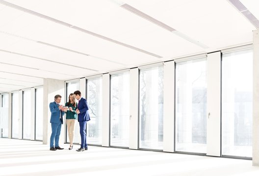 Full length of business people using digital tablet in new office - Powered by Adobe