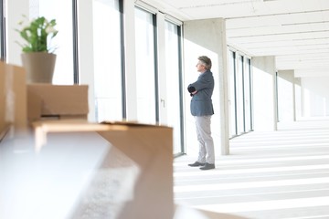 Side view of mature businessman looking through window in new office