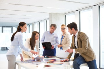 Male and female design professionals having discussion at table in new office