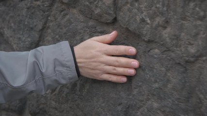 Hand on stone wall. Woman's hand on an old stone wall.