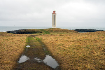 Kalfshamarsvik lighthouse in the western part of Iceland during rainy weather. Grassy countryside...