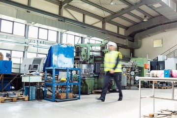 Blurred motion of male supervisor walking in metal industry