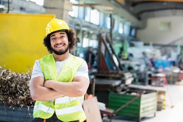 Portrait of smiling male manual worker standing arms crossed in metal industry