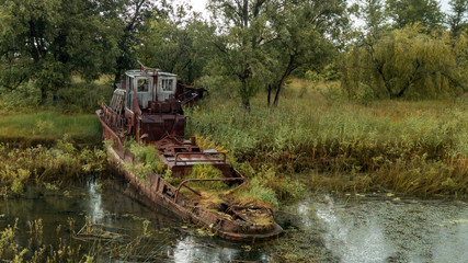 Fototapeta premium Aerial view abandoned ships in the river near of Chernobyl. The abandoned river port in Pripyat. Modern ruins. Radioactive metal.