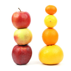 apples and citrus stand vertically on each other on white background