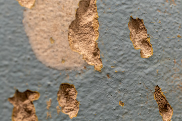 Tiled wall. Preparation for repair. Broken and gritty surface. Rough texture of blue color with brown spots.