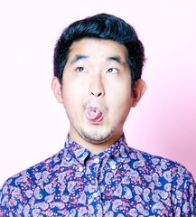 Young Geeky Asian Man in colorful shirt pulling funny face