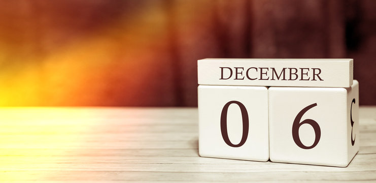 Calendar reminder event concept. Wooden cubes with numbers and month on December 6 with sunlight.