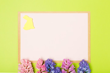 Easter composition with hyacinths, rabbit and blank paper. Background. Easter concept. Flat lay, moke up. 