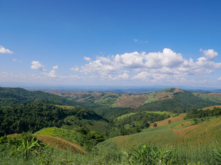 Mountains that are partially cleared for agriculture.Mountain views against the sky with white clouds.