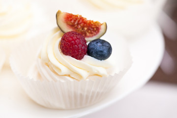 Fresh cupcake muffins with raw berries. Cupcakes decorated with fresh berries. Macro