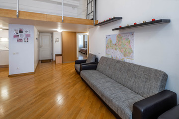 Modern interior of studio apartment. Wooden table. Cozy couch.