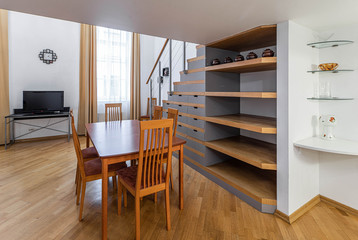 Modern light interior. Wooden furniture and shelves. Staircase. Studio apartment.