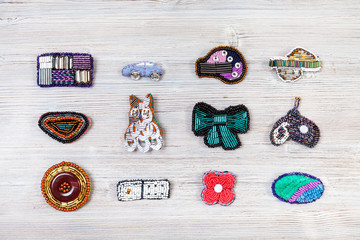 various handcrafted embroidered brooches on gray