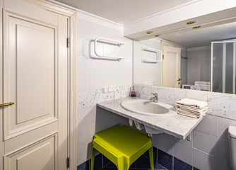 Closed door to the bathroom. Modern interior. White tile.