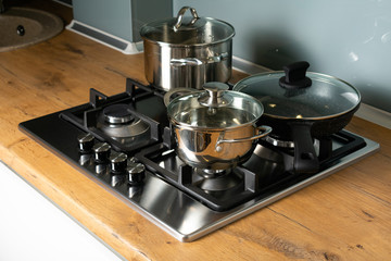 Modern stainless steel gas stove oven in a home with various cookware