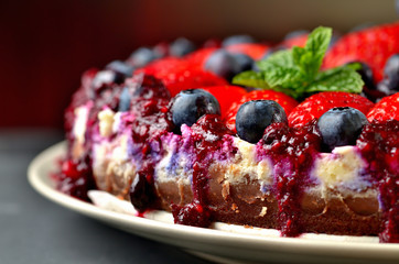 Cake with fresh strawberries, blueberries and cherry jam. Low depth of field
