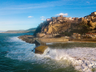 Aerial view of a pier with rocks. Pizzo Calabro pier, panoramic view from above. Broken pier, force of the sea. Power of Waves. Natural disasters, climate change. Calabria, Italy.       