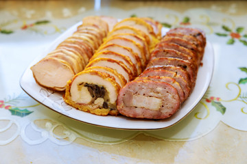 Cut stuffed meatloaf roll on white plate for party.