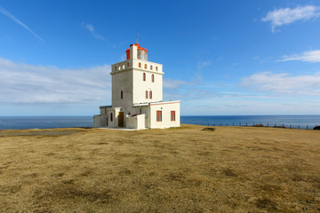 Fototapeta na wymiar White lighthouse against a cold Atlantic ocean