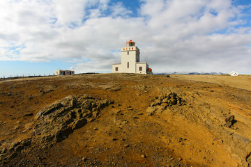 Fototapeta na wymiar White lighthouse against a cold Atlantic ocean