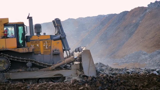 Yellow tracked bulldozer moves your bucket stones
