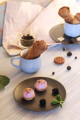 Chocolate ice cream in waffle cones, cookies, berries on a wooden table, sweet dessert for home holiday