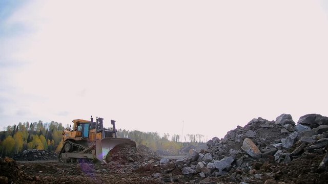 Wide-angle panorama Yellow tracked bulldozer moves your bucket stones