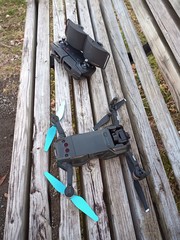 Drone sitting on park bench with remote.