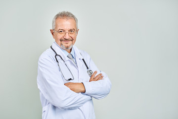 Cheerful mature doctor posing and smiling at camera, healthcare and medicine.