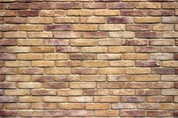Fototapeta premium A brick wall consisting of bricks of various shades of brown. Antique decorative background or retro style.