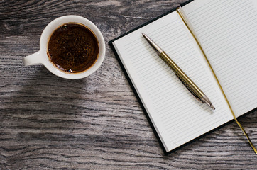 cup of coffee and notebook on wooden table