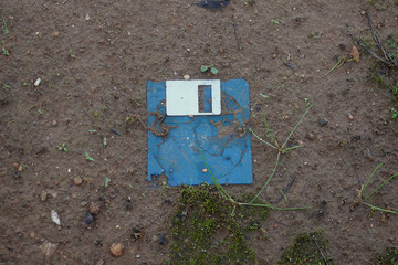 broken floppy disk on muddy ground