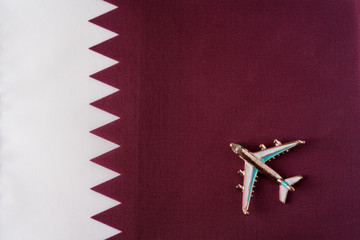 Plane over the flag of Qatar travel concept.