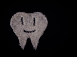 Happy little sugar tooth character isolated on a black background top view with copy space. .Dental care concept.