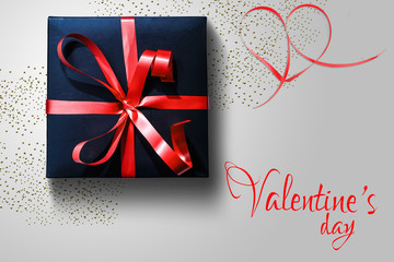 Black gift box with red ribbon on background. Holiday concept, Valentine's Day. Congratulations background