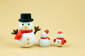 Snowman of various size on yellow background
