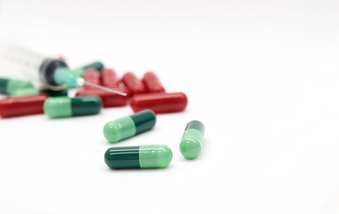 Green capsules red capsules and a syringe isolated