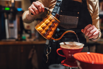 Barista brewing filter coffee in coffee shop