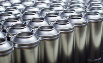 A large number of aerosol cans on a black background.