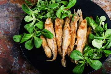 Fried smelt on a black plate