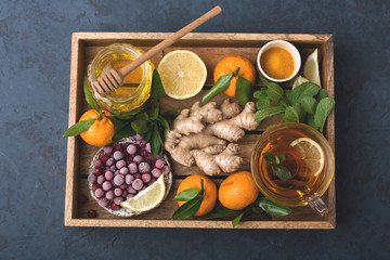 Health and diet content. Natural immune system support kit-ginger, lemon, frozen cranberries, mint tea, turmeric, tangerines. Ascorbic acid. Top view.