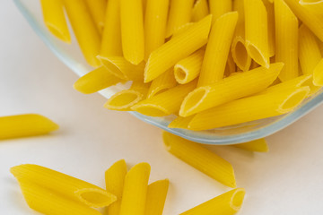 Uncooked organic pasta in a clear glass bowl. 