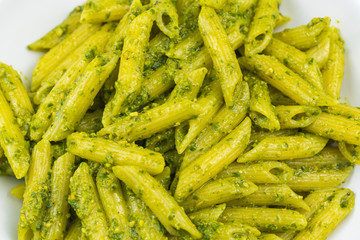 Cooked organic pasta with homemade pesto sauce. 