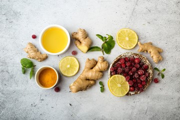 Healthy food, immunity kit, vitamin C-honey, ginger root, lemon, cranberry, mint, turmeric. On a gray background, top view.