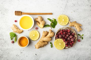 Healthy food, immunity kit, vitamin C-honey, ginger root, lemon, cranberry, mint, turmeric. On a gray background, top view.