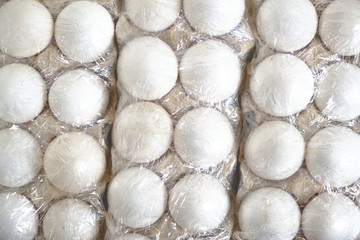 White chicken eggs in a paper tray.