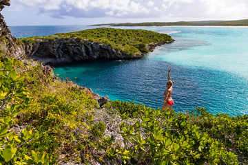 Happy woman posing in front of Dean's blue hole, Long Island, Bahamas