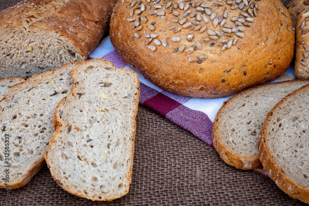 Poster fresh bread on table. baked dark bread and sliced bread.