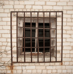 texture of a brick wall with a window behind bars